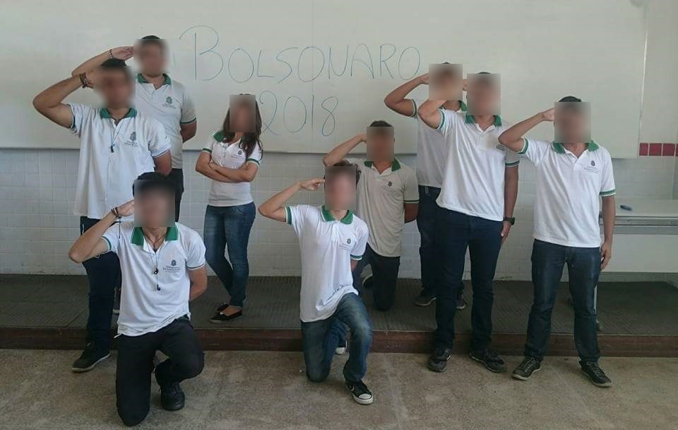 Os estudantes da escola pública estadual Professora Alda Façanha denunciaram que foram suspensos após demonstrarem apoio à candidatura do deputado federal Jair Bolsonaro para presidente em 2018. O colégio fica localizado no município de Aquiraz, Região Metropolitana de Fortaleza. A polêmica surgiu no dia 13 de setembro, quando nove estudantes se reuniram e tiraram uma foto em frente ao quadro da sala de aula com a frase “Bolsonaro 2018”. A ação faz parte de uma campanha nas redes sociais promovida por páginas de direita. Depois de divulgarem a foto no Facebook, a imagem repercutiu. Em menos de 24h, a publicação já possuía mais de 15 mil curtidas e 600 compartilhamentos. No entanto, a forma que o caso foi tratado pela direção do colégio está causando uma insatisfação nos estudantes. Conforme um dos alunos, que o Tribuna do Ceará optou por manter seu nome em sigilo, todos os estudantes que estão presentes na fotografia foram suspensos. Ainda segundo o aluno, os jovens não podem frequentar as aulas e nem os estágios nos quais participam dentro da instituição. “Quando nos recusamos a apagar a foto, afirmaram que nós tomaríamos consequências de nossos atos, por isso nos suspenderam”, destacou um dos estudantes.